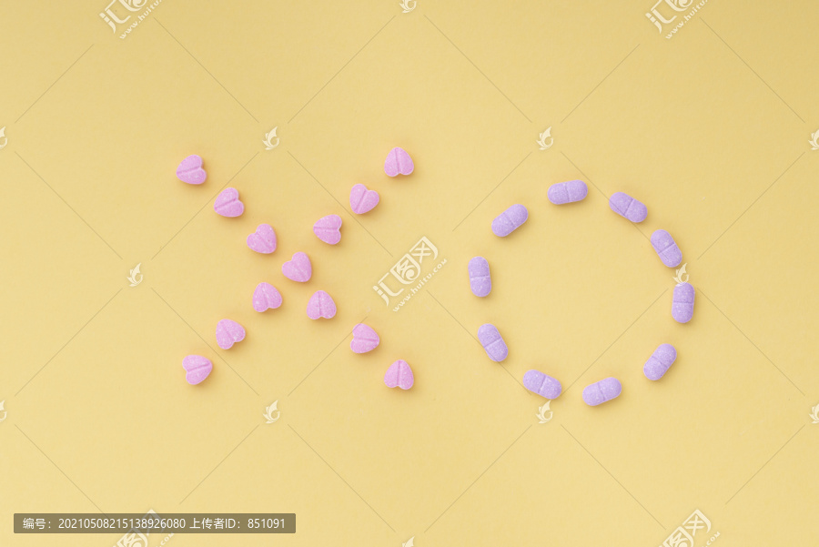 Tic-tac-toe游戏由亮黄色背景上的紫色和粉色药丸制成。