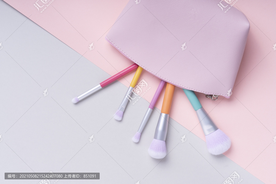顶视图-五颜六色的彩虹粉彩刷在明亮的粉红色和蓝色背景上的粉红色袋子。