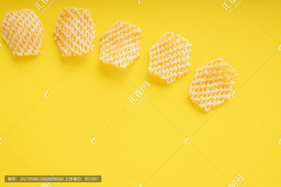 顶视图-黄色背景上的薯片。复制空间。