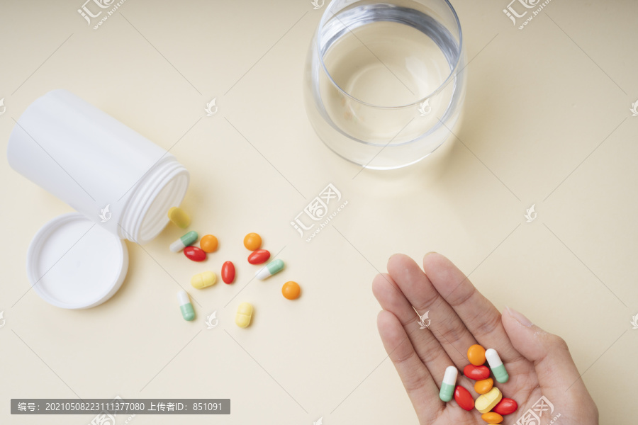 人药丸胶囊概念。从白色瓶子里拿药片，然后是水。
