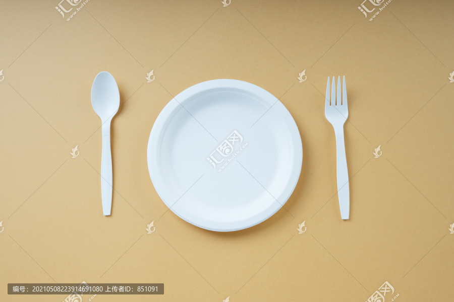 顶视图-塑料板、勺子和叉子。一次性使用。