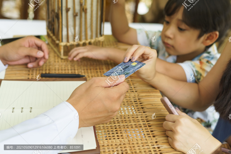 亚洲夫妇用信用卡支付酒店费用。数字货币。