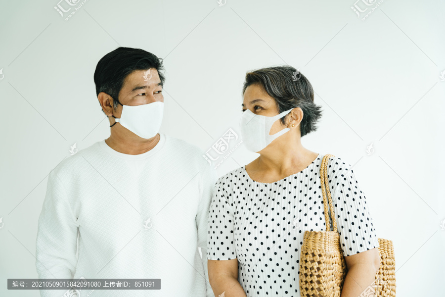 一对穿着白衬衫、戴着面具的老夫妇的肖像。
