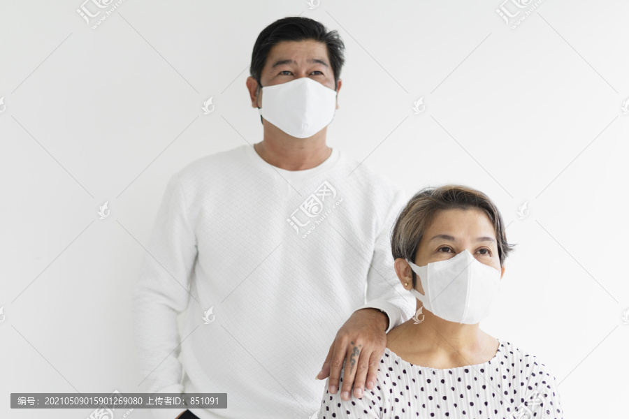 一对穿着白衬衫、戴着面具的老夫妇的肖像。