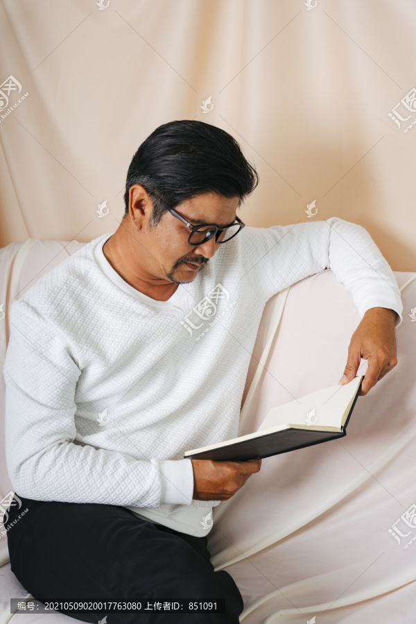 一幅时髦的老人戴着眼镜看书的画像。
