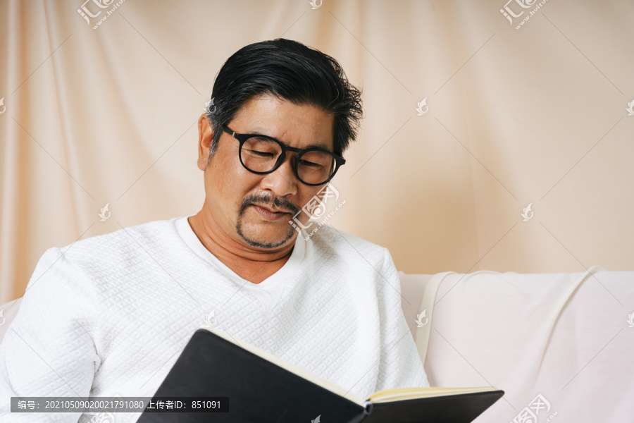 一幅时髦的老人戴着眼镜看书的画像。