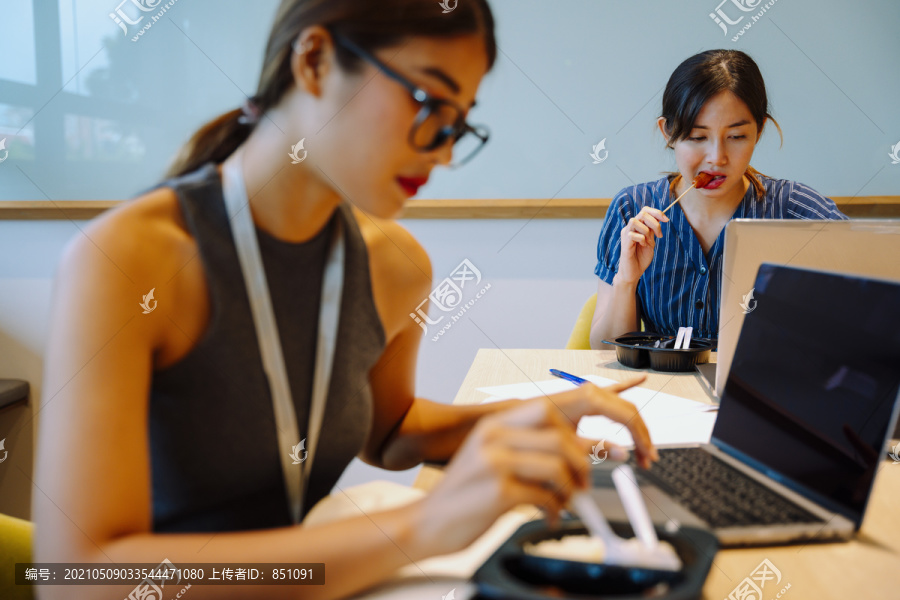 亚洲女商人在午休时间同时工作。