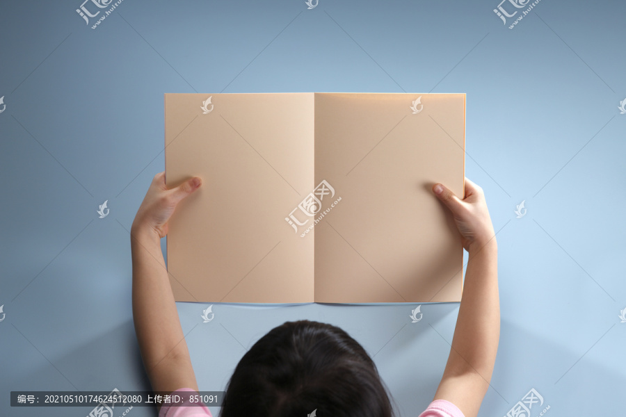 一个女孩拿着一本空白的书。
