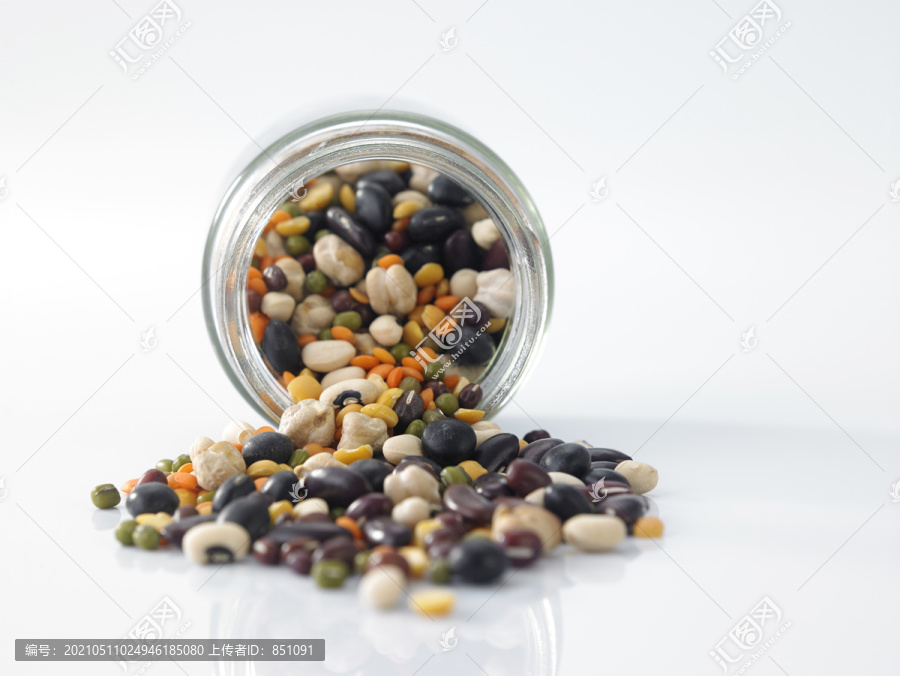 将黑眼豆、绿豆、红豆、黄豆、黑豆和红芸豆混合在白色背景上的泥瓦匠罐中