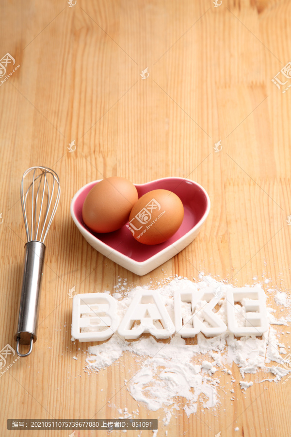 烘焙概念，手打蛋器和鸡蛋放在心形容器中