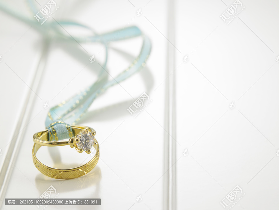 用绿丝带连接的结婚戒指