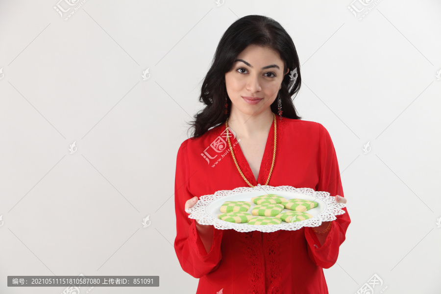 凯巴亚的女人端着一盘拉亚饼干准备上菜