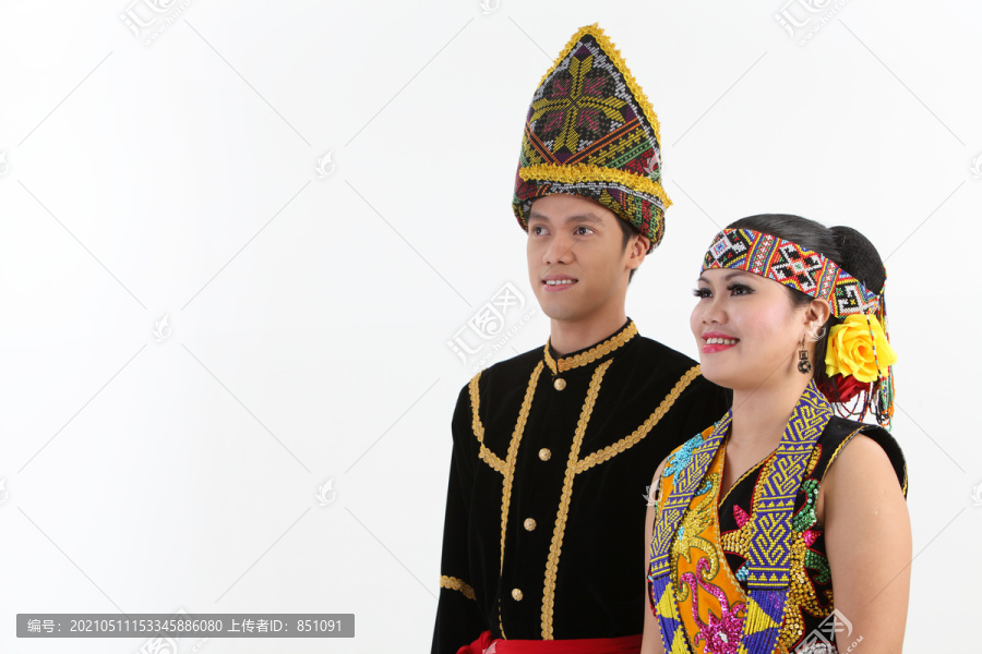 来自婆罗洲的一对穿着传统服装的夫妇看着别处
