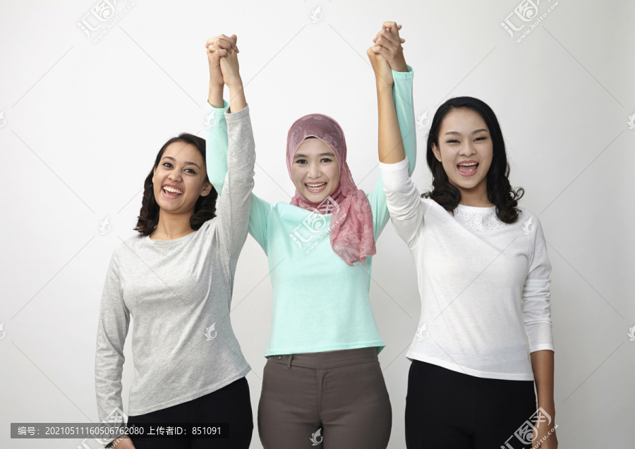 三个多种族的马来西亚人手牵手看着摄像机