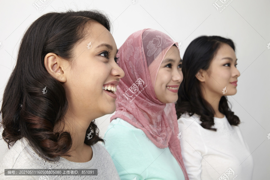 三个不同种族的马来西亚人站成一排看着远方