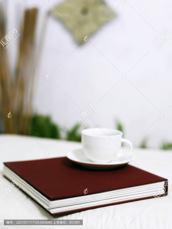 一杯咖啡和一本书在花园旁边