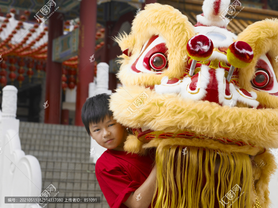 穿红衫的男孩举起狮子头