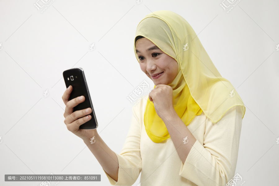 马来女子手持智能手机自拍