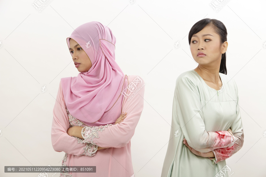 两个女朋友站在白色背景下不满并发生争吵