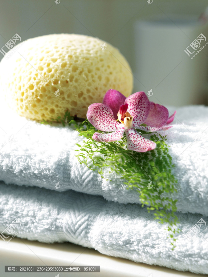 一堆毛巾上的海绵和花