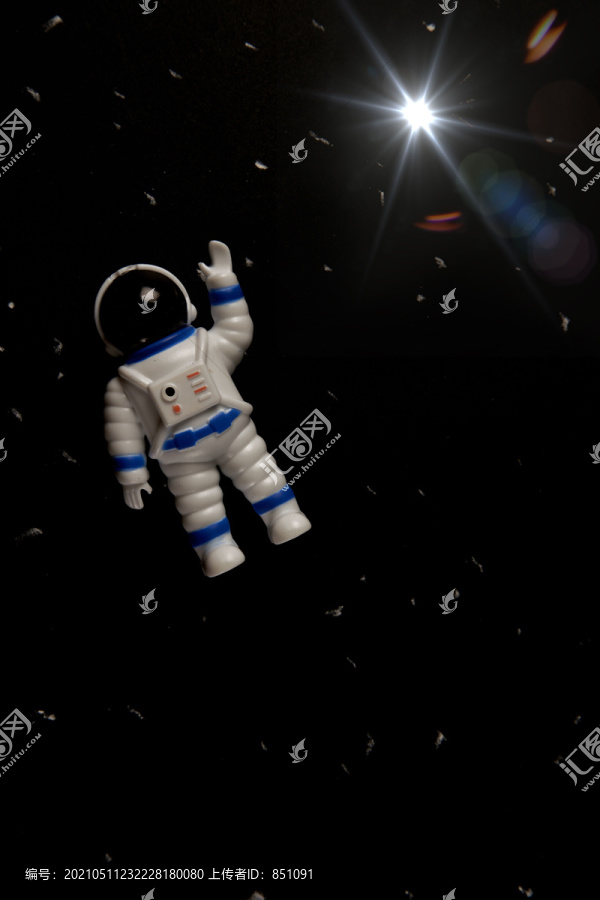 太空人玩具在黑暗背景下的平面布局。