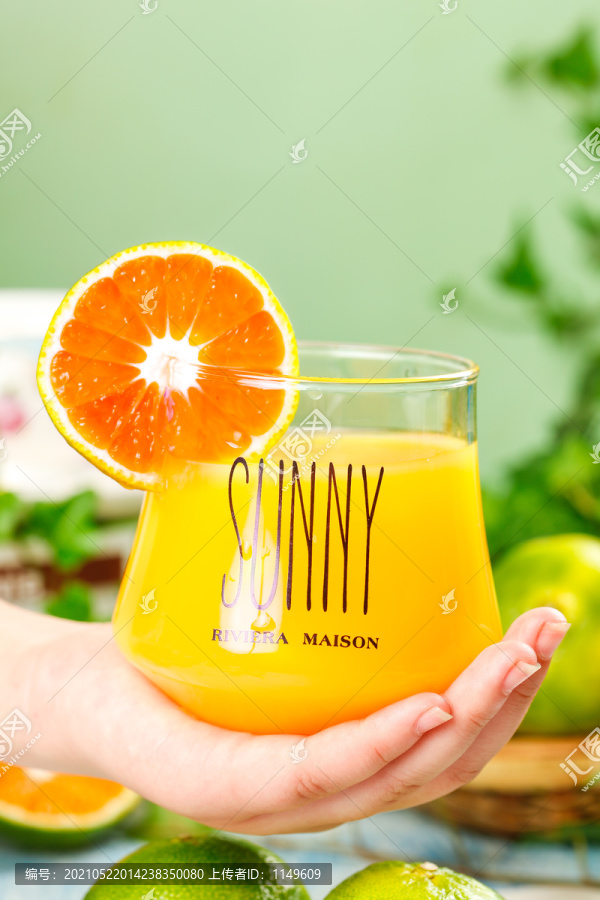 手上端着一杯橘子汁
