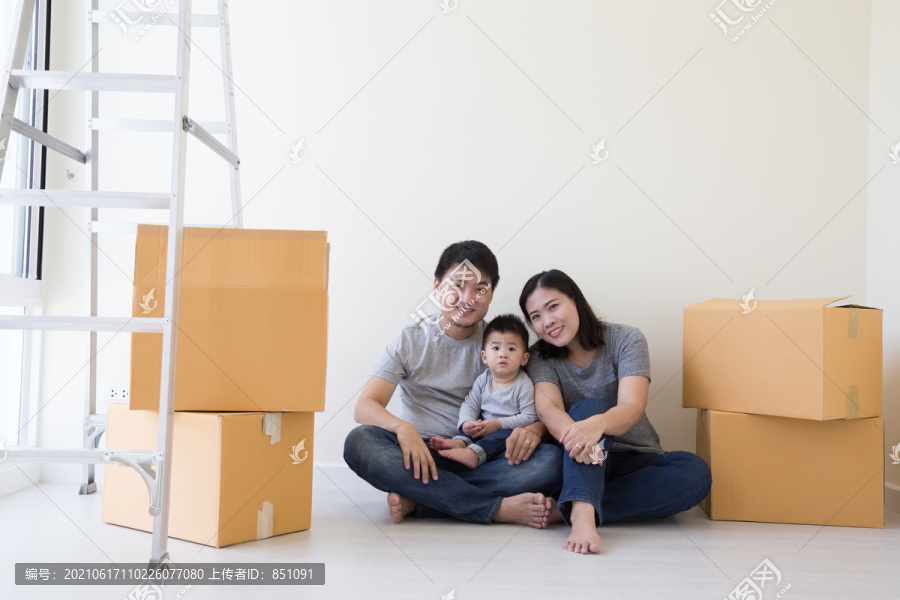 父母和儿子在一个新家里。居住一个年轻的亚洲家庭概念
