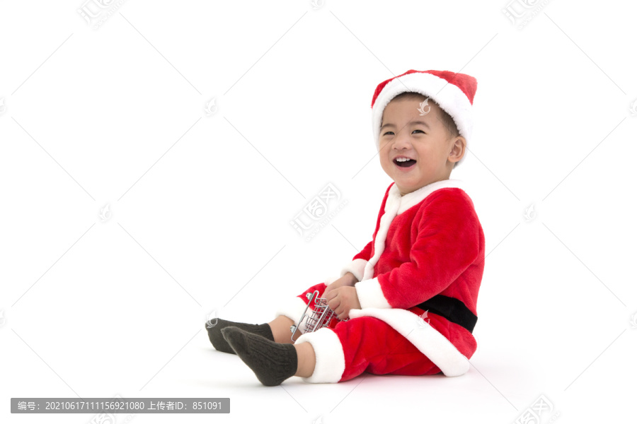 快乐的亚洲男婴穿着白色背景上的圣诞老人的圣诞服装欢笑