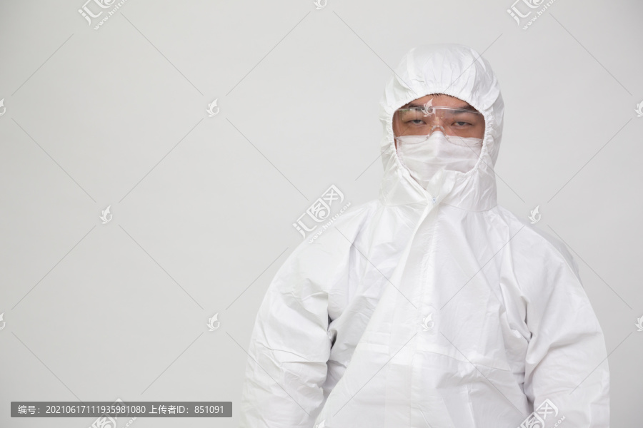 穿着个人防护装备或PPE套装，戴口罩和眼镜的亚洲医生或护士肖像