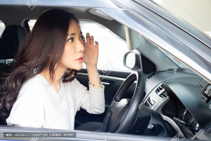 漂亮的亚洲女司机在车上化妆