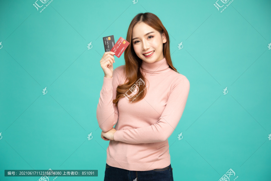 亚洲女性微笑、展示、出示信用卡进行支付或支付在线业务、向商户付款或作为商品、持卡人或持卡人的现金预付
