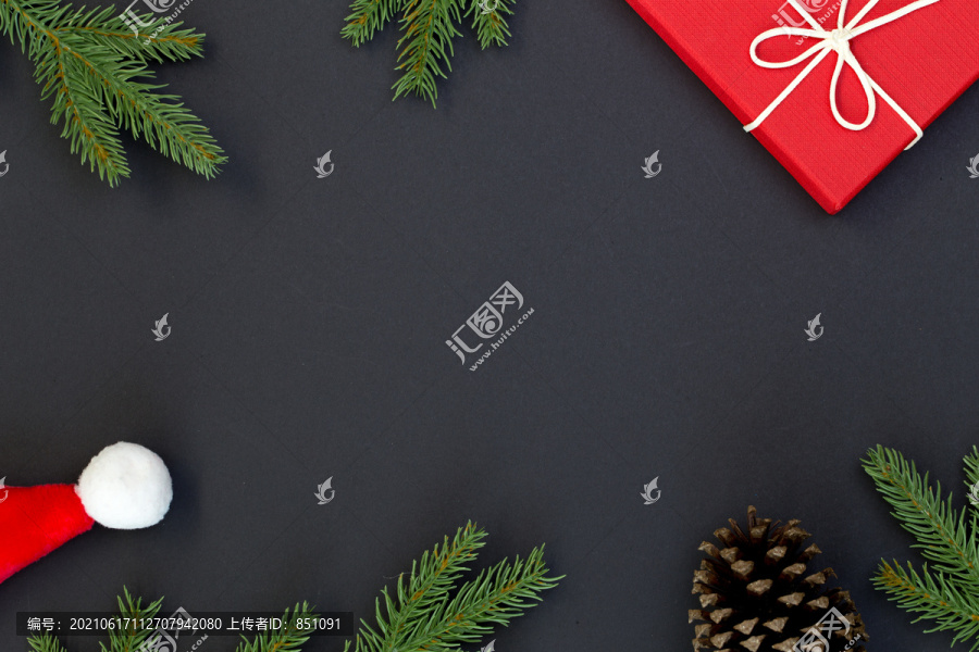 圣诞构图俯视图、礼品盒、松果、黑色背景上的冷杉枝以及文本信息的复制空间