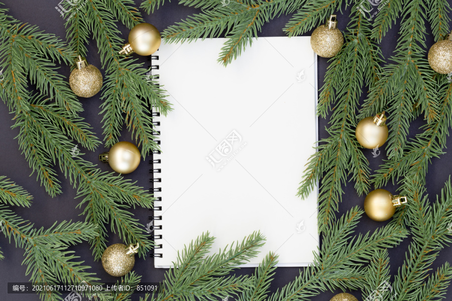 白纸和圣诞装饰的俯视图，黑色背景上的松果、冷杉枝和文本信息的复制空间
