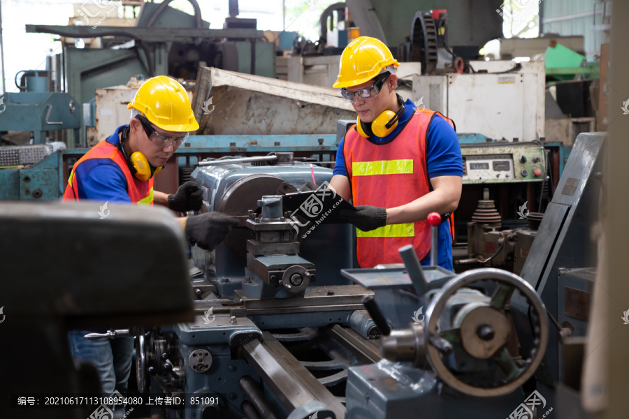 亚洲工厂工程师戴黄色安全帽检查机器，年度维护概念