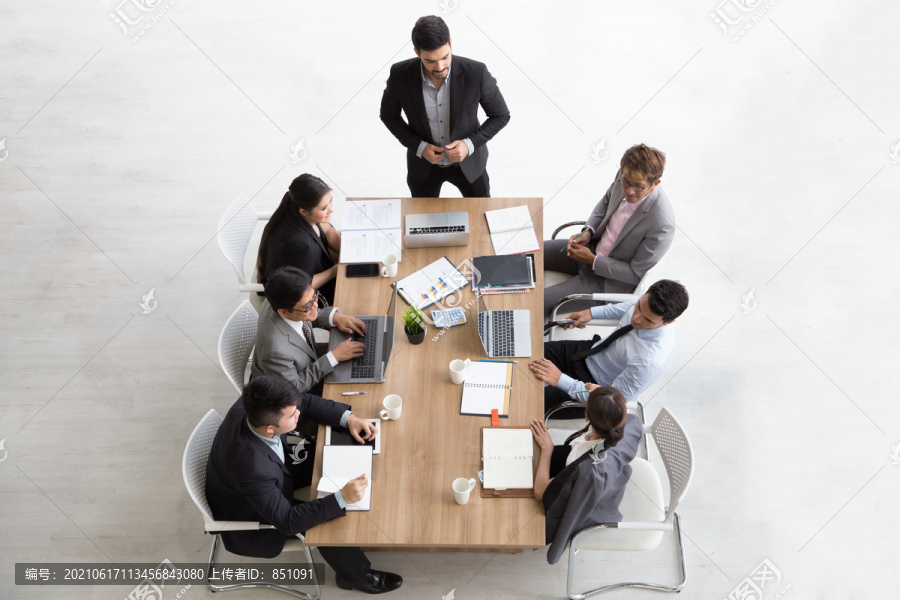 在办公室工作的多民族忙碌人群俯视图，商人和女商人围坐在空白复印空间的会议桌旁的鸟瞰图，商务会议概念