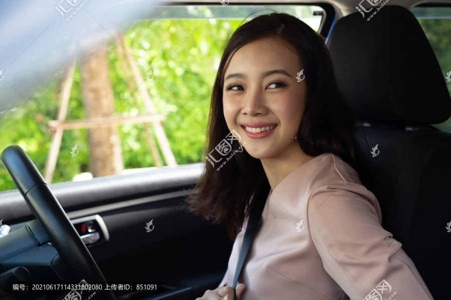 司机亚洲女性在开车前坐在车内系上安全带，并安全出行