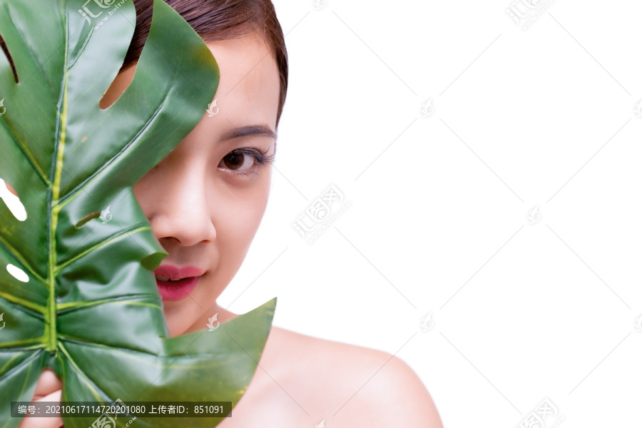 快乐美丽的年轻亚洲女性，拥有干净清新的皮肤和绿叶，女孩美容面部护理，面部护理和美容spa概念