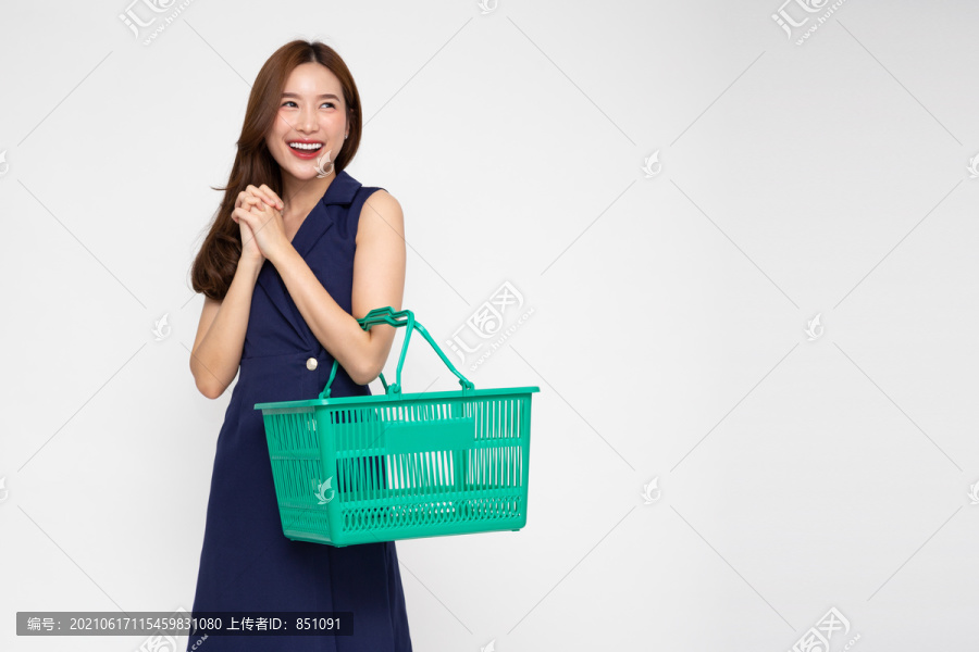 美丽的亚洲女人微笑着，拿着白色背景上的购物篮
