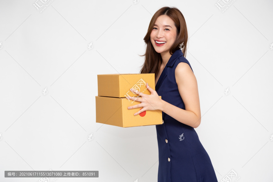 快乐的亚洲女人微笑着拿着白色背景上隔离的包裹盒，快递和运输服务理念