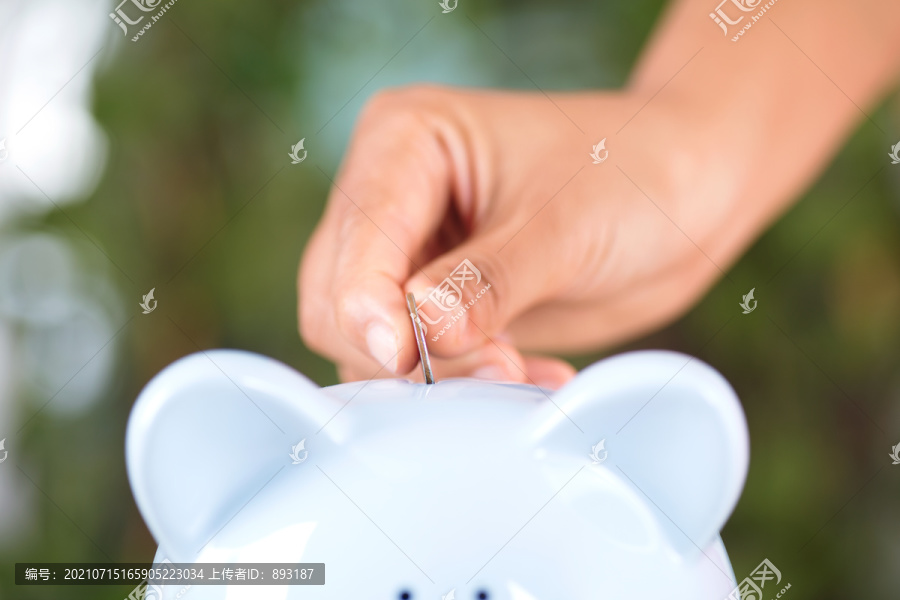 把零钱硬币放入小猪存钱罐