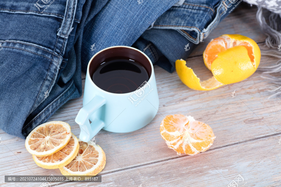 衣服旁的一杯热茶和橘子及柠檬片