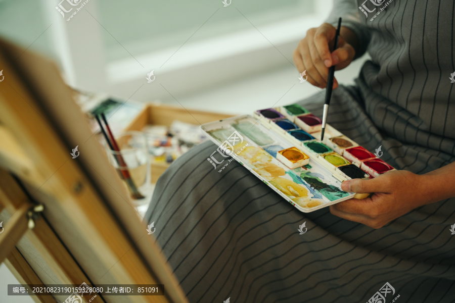 专业的色彩画家，在画室从事绘画工作的女性。