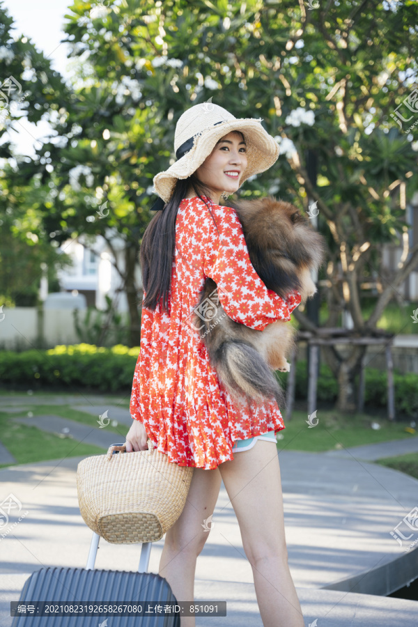 美麗的亞洲女旅行者帶著她的狗在度假村和酒店里旅行。
