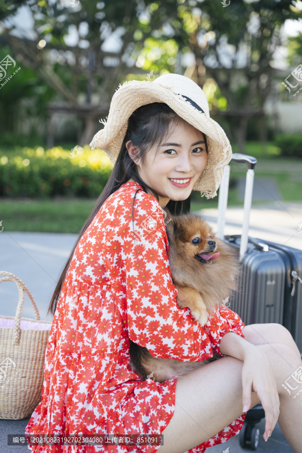 美麗的亞洲女旅行者帶著她的狗在度假村和酒店里旅行。