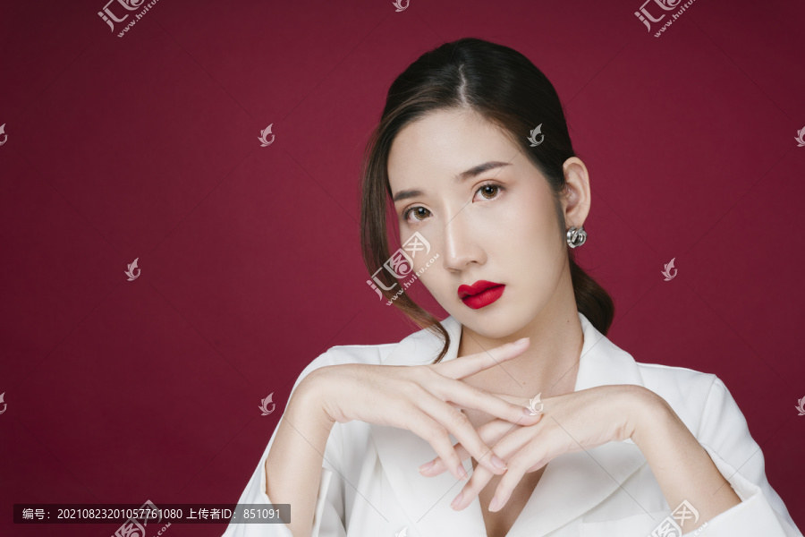 美丽的亚洲年轻女子的画像，涂着红色的口红，穿着白色西装外套。