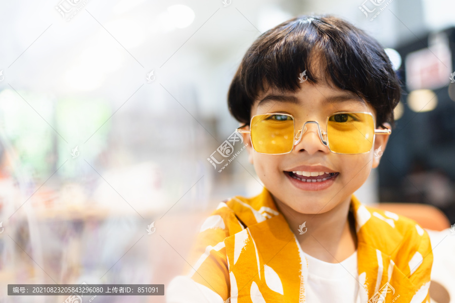 聚会上穿着黄色衬衫戴眼镜的小男孩的画像。