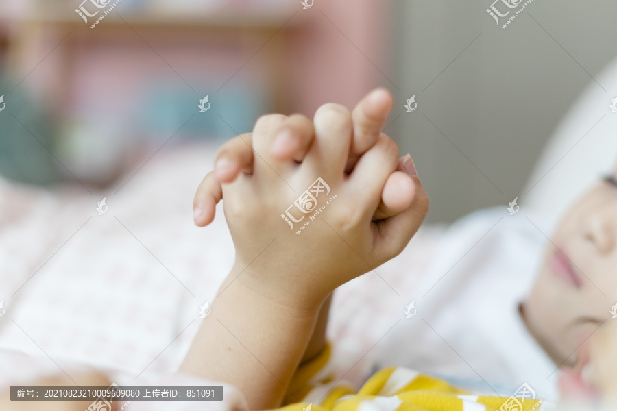 两个孩子在睡觉的时候手拉手。