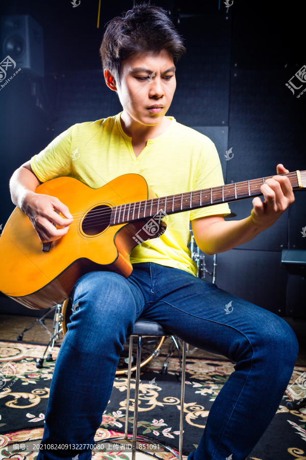 亚洲专业吉他手在录音室演奏原声吉他音乐