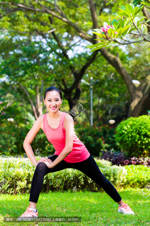 亚洲华人女子在城市公园伸展肌肉健身