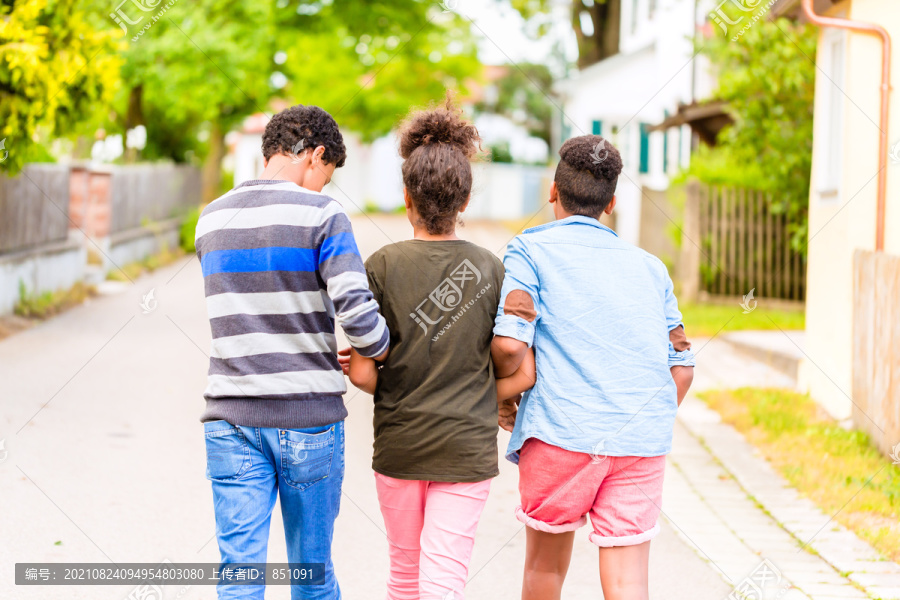 兄弟姐妹，黑人女孩和两个男孩，走在村道上